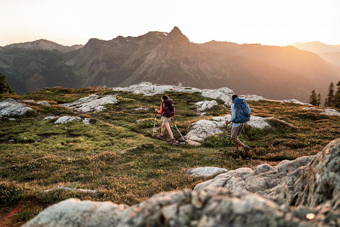 Two hikers on the trail overlooking mountain range