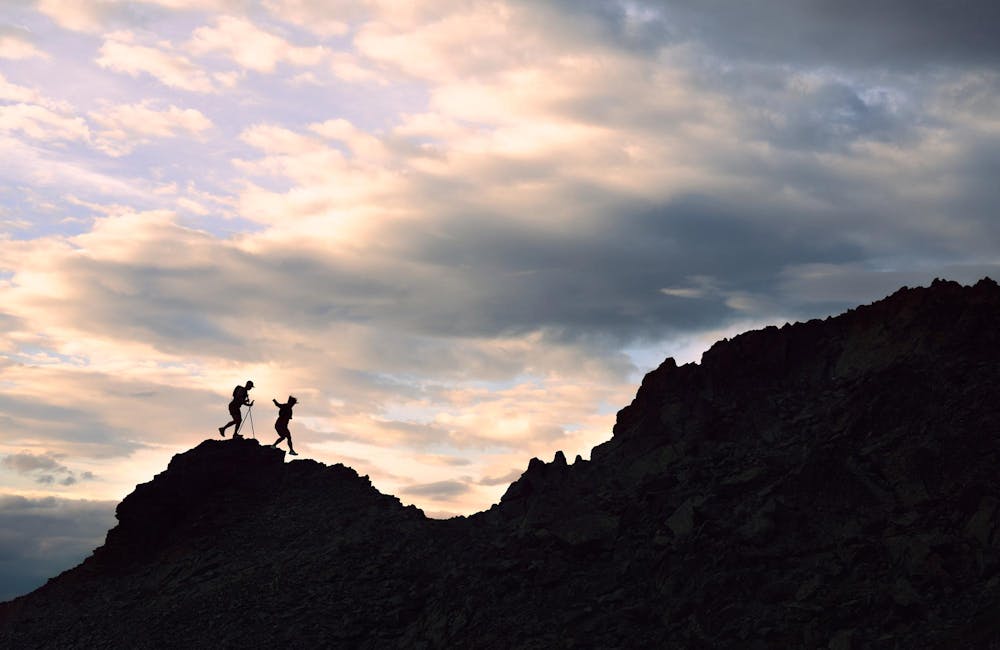Two hikers trail running up a rocky face in Oboz Katabatic Wind shoes.
