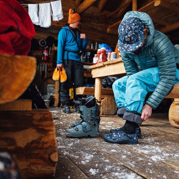 A woman puts on the Oboz and Skida Whakatā Puffy's after a day of skiing