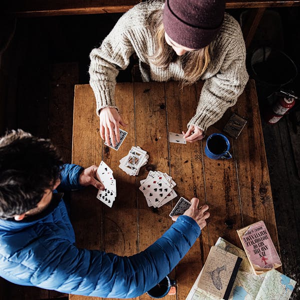 Two people playing cards in a cabin.