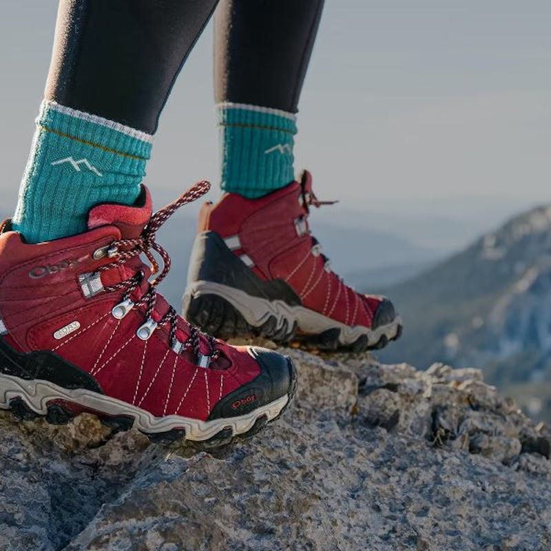 Oboz Bridger hiking boot in Rio Red on a mountain top.