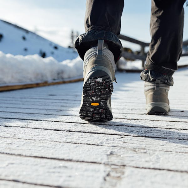Oboz Andesite insulated winter boot on a snowy wooden boardwalk.