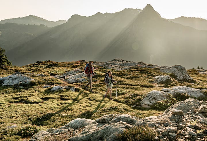 Two hikers on a beautiful rocky trail in the mountains.