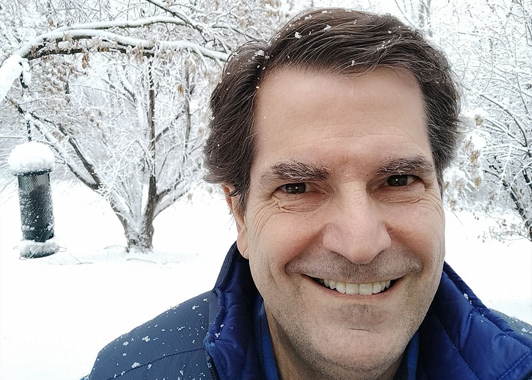 Joel in front of snowy trees in the winter.