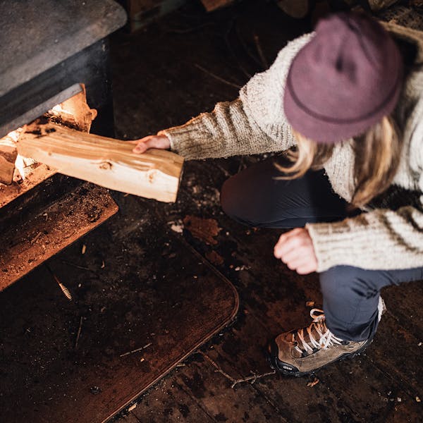 Woman stoking the fire in the Oboz Bridger Winter Insulated Boots.