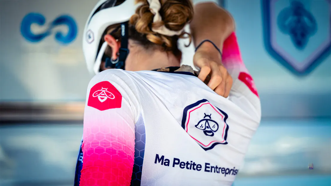 Une cycliste de dos, portant un maillot Ma Petite Entreprise