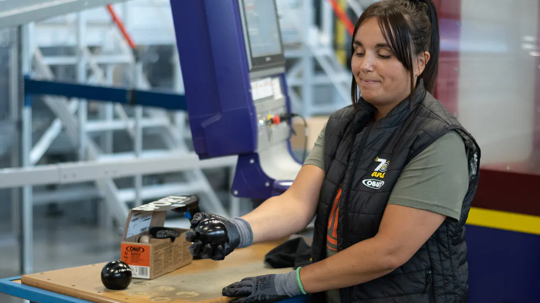 Une collaboratrice Obut, dans l'atelier de personnalisation, contrôlant la gravure d'une boule