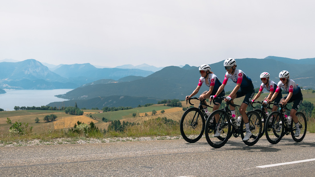 Les cyclistes féminines de l'équipe Ma Petite Entreprise sur les routes du Tour de France avec un lac en fond