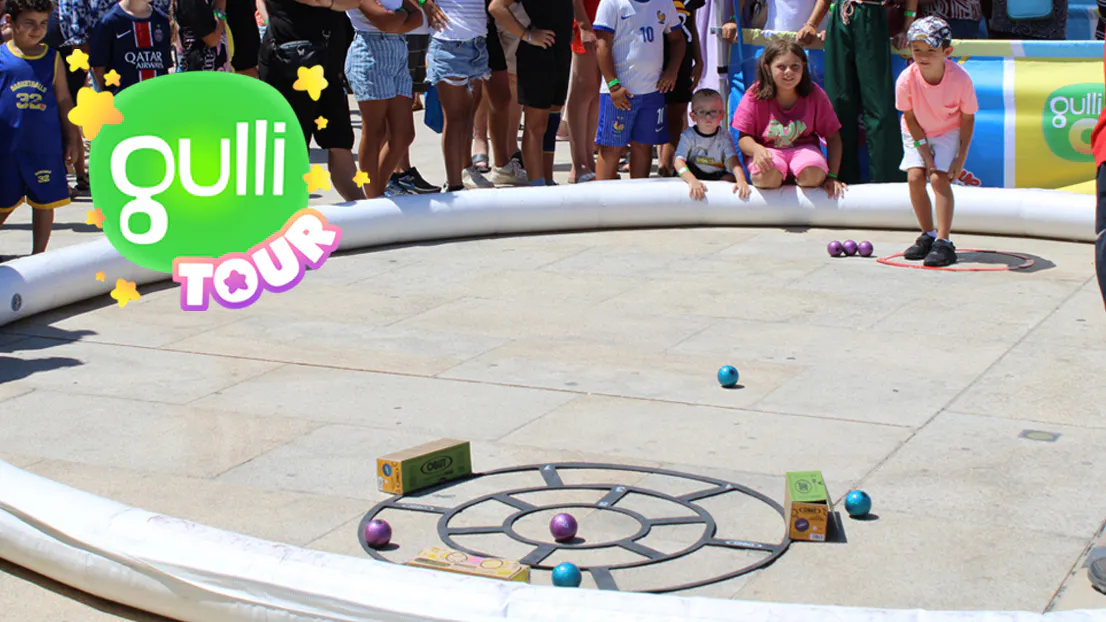 Child playing pétanque on a court set up during the Gulli Tour