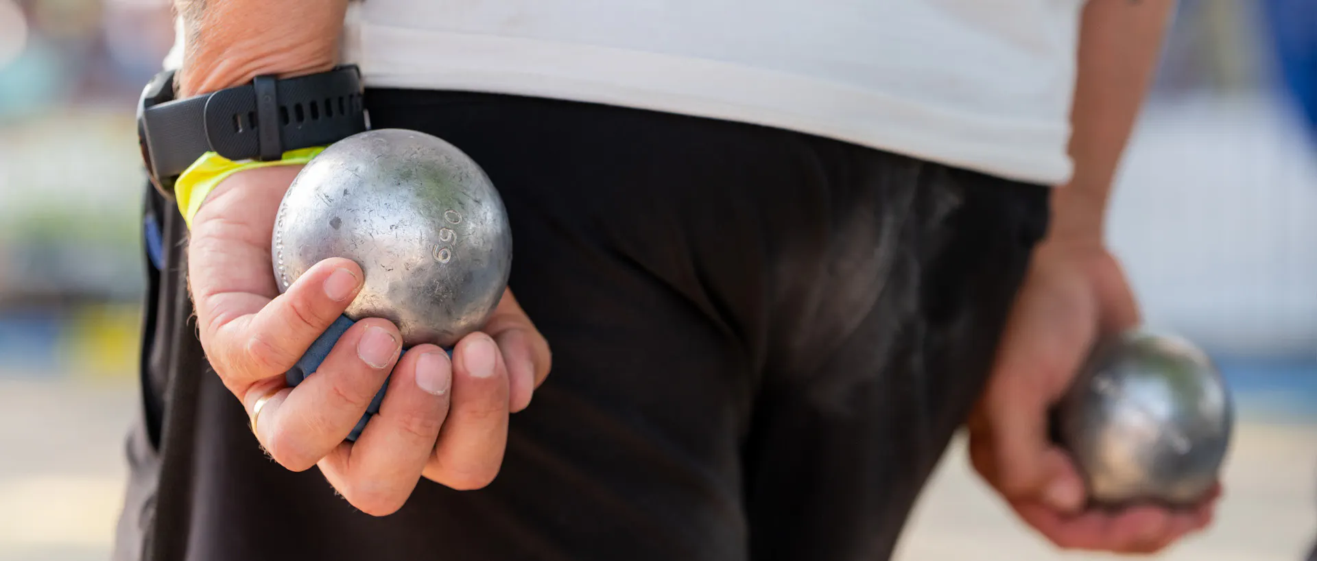 Un joueur de pétanque avec une boule Obut dans chaque main