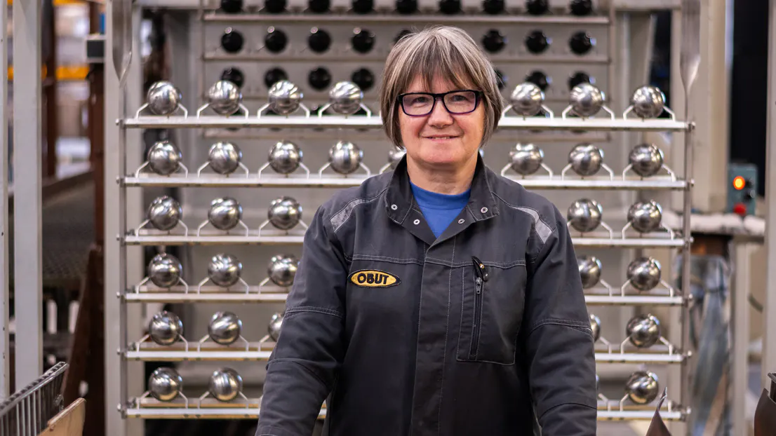Eliane au poste de finition des boules de pétanque de compétition Obut
