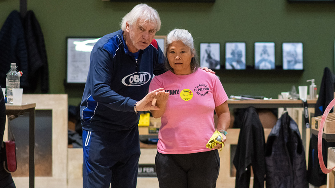 Marco Foyot conseillant une participante lors du Stage des Légendes Obut sur un terrain de pétanque
