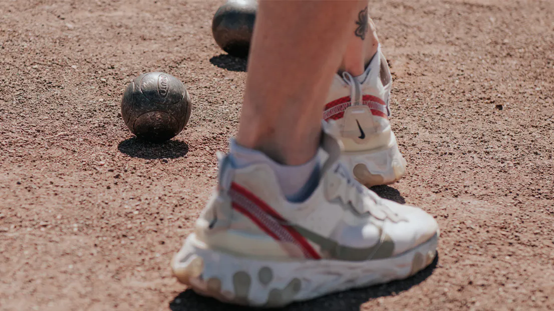 Joueur sur un terrain de pétanque avec des boules de pétanque Obut