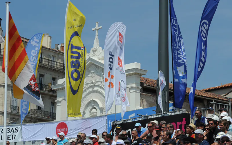 Ambiance de tournoi de pétanque avec drapeaux Obut et spectateurs