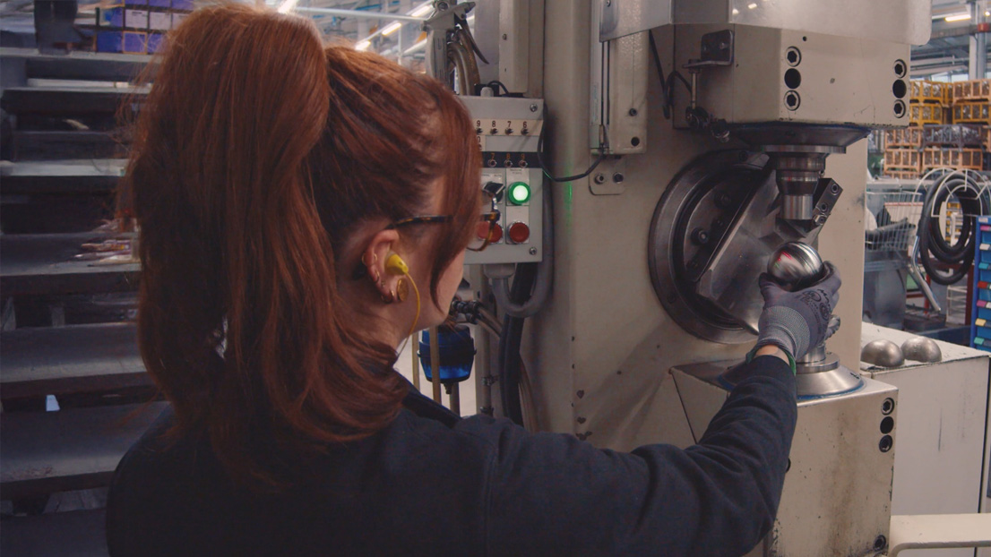 Amaurie, devant sa machine de striage dans les ateliers Obut