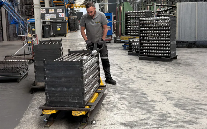 Un collaborateur manipulant le matériel de mise à hauteur pour ajuster sa surface de travail à sa hauteur.