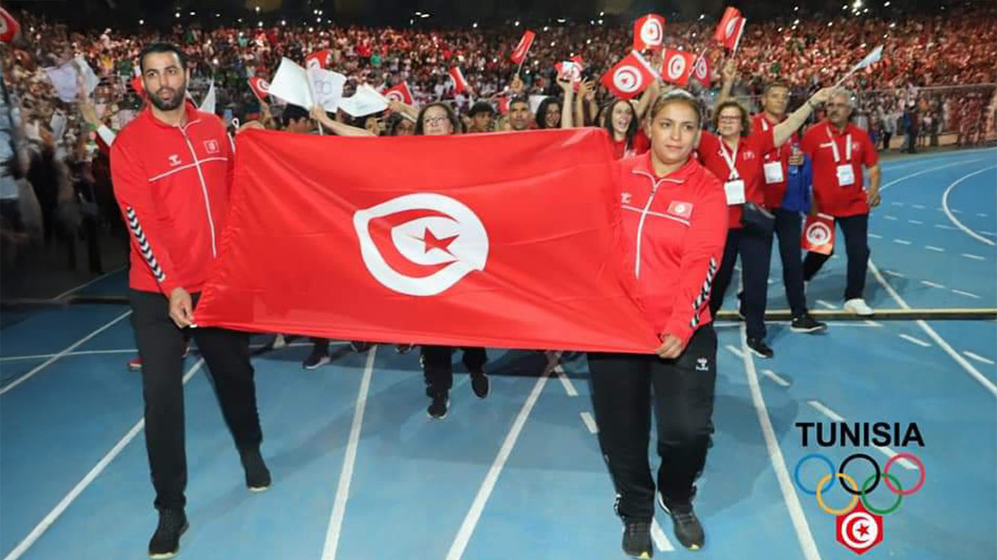 Mouna Beji carrying the flag after winning a gold medal at the Mediterranean Games.