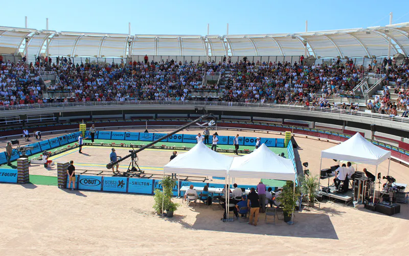 Tournoi de pétanque sur un terrain de jeu et tribunes remplies de spectateurs