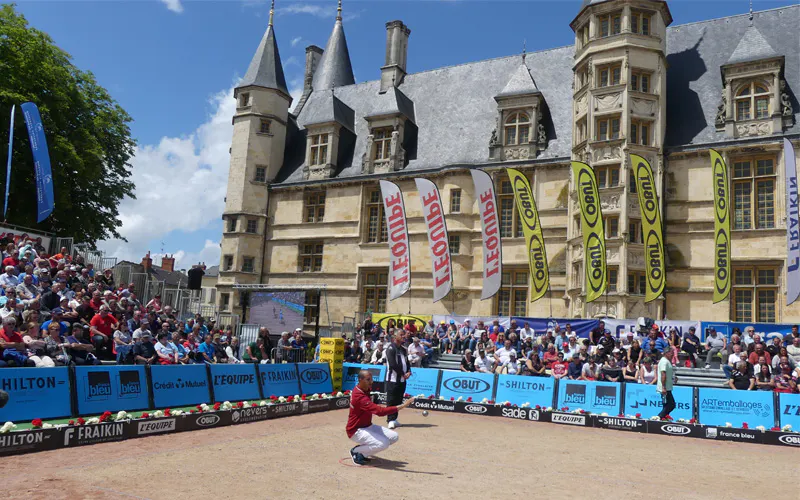 Joueur de pétanque en action lors d'une partie des Master à Nevers devant un public