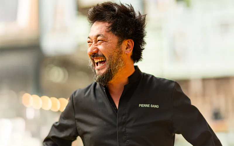 Pierre Sang, chef cuisinier, souriant lors d'un événement gastronomique en plein air