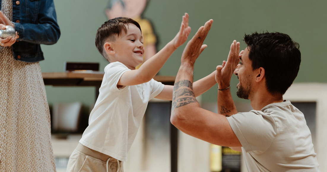 Un papa et son fils se tapant dans les mains lors d'une partie de pétanque