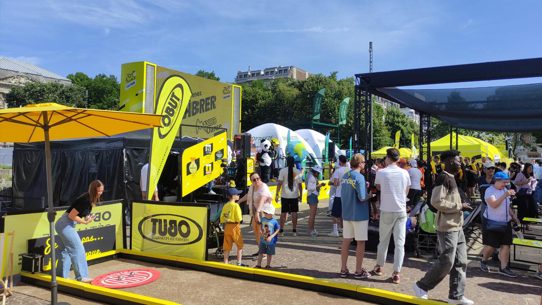 Une personne jouant à la pétanque sur un terrain de pétanque Obut lors d'une étape du Tour de France