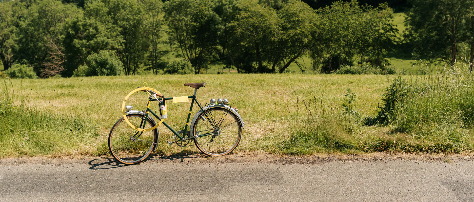 Un vélo posé le long d'un champ avec du matériel Obut