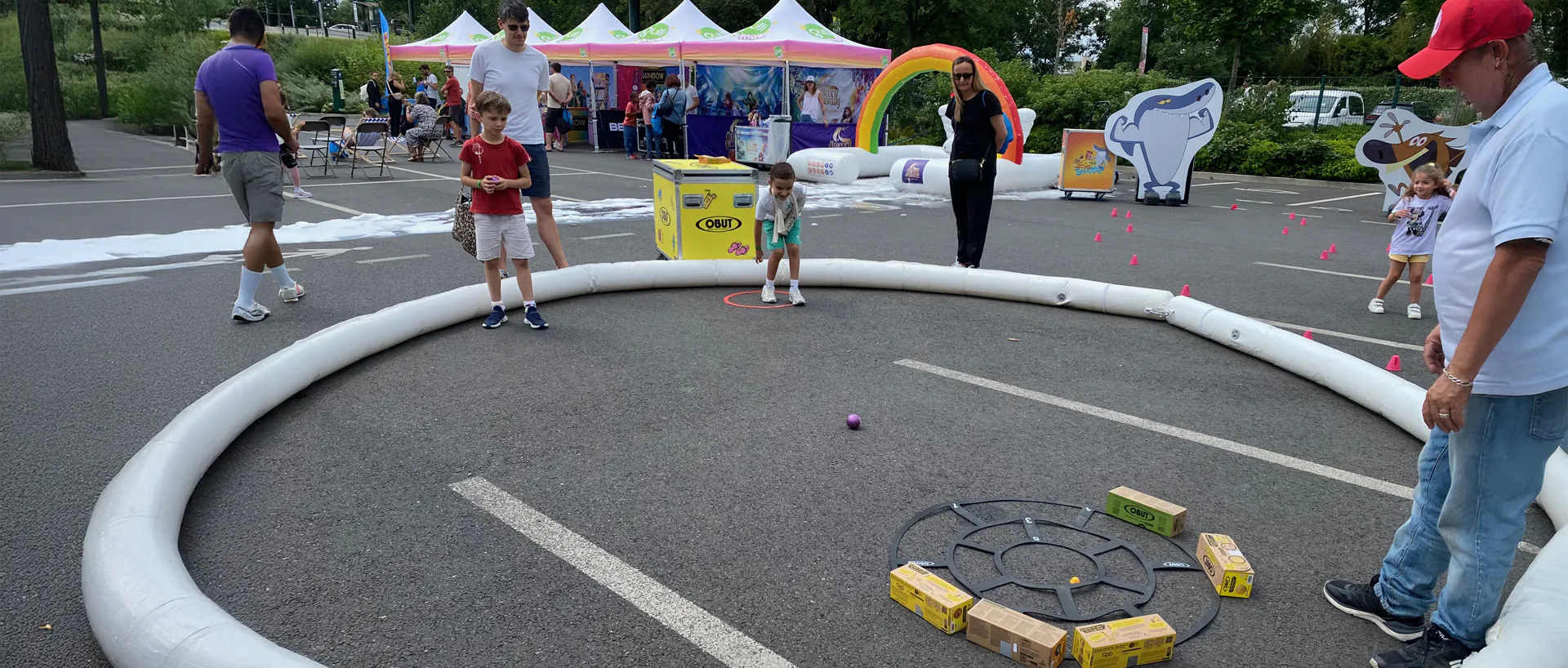 Children playing pétanque with guidance from the host during the Gulli Tour