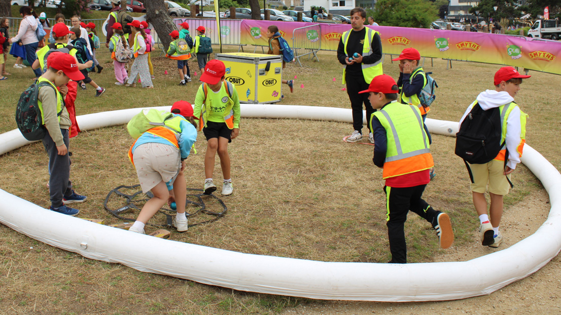 Several children playing pétanque on a court set up for the Gulli Tour