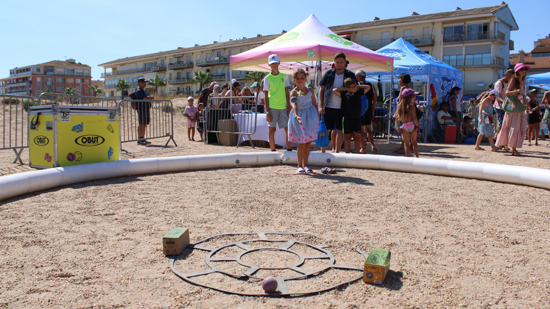 A young girl playing pétanque on a temporary court during the Gulli Tour