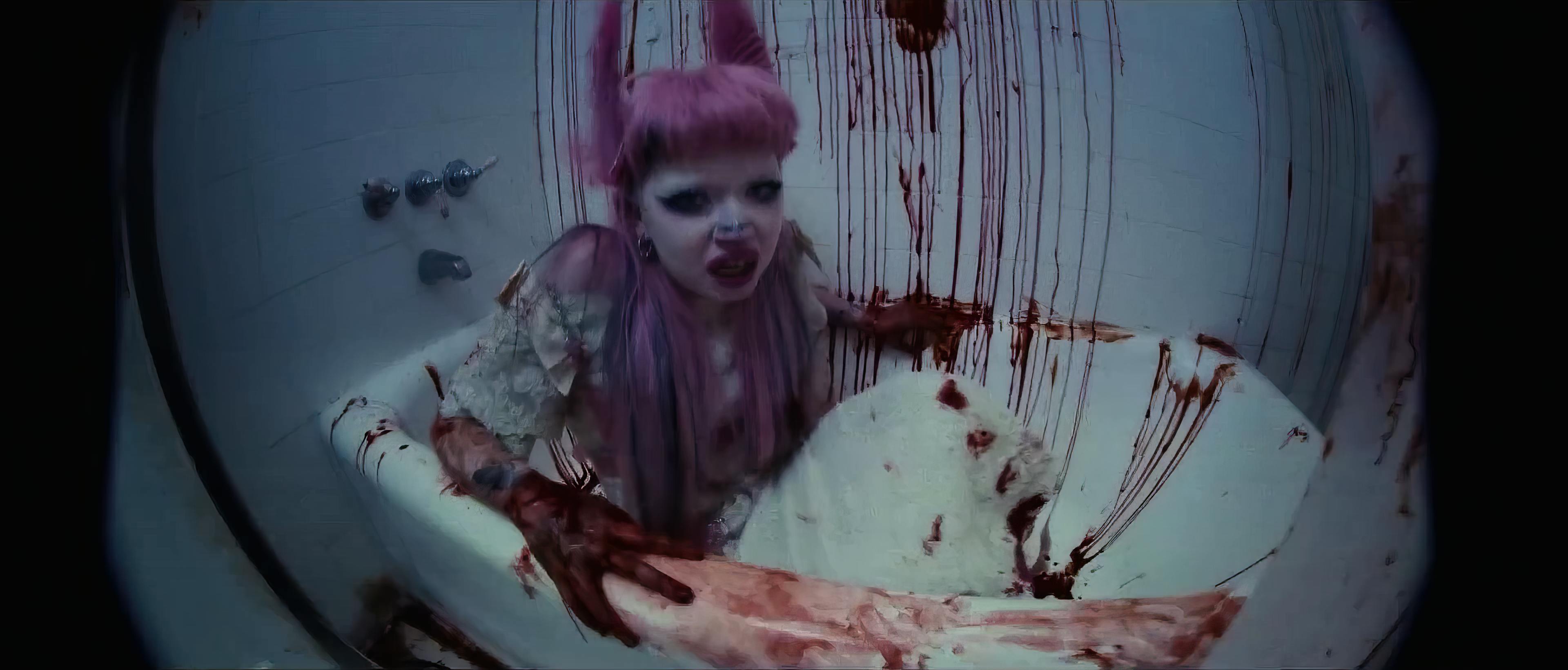 An artist in a bathtub, the scene styled with horror elements. They have vibrant purple hair, and their makeup and pose contribute to an intense and dramatic visual theme. The bathtub and surrounding tiles are smeared with what appears to be blood, enhancing the eerie, cinematic quality of the image.