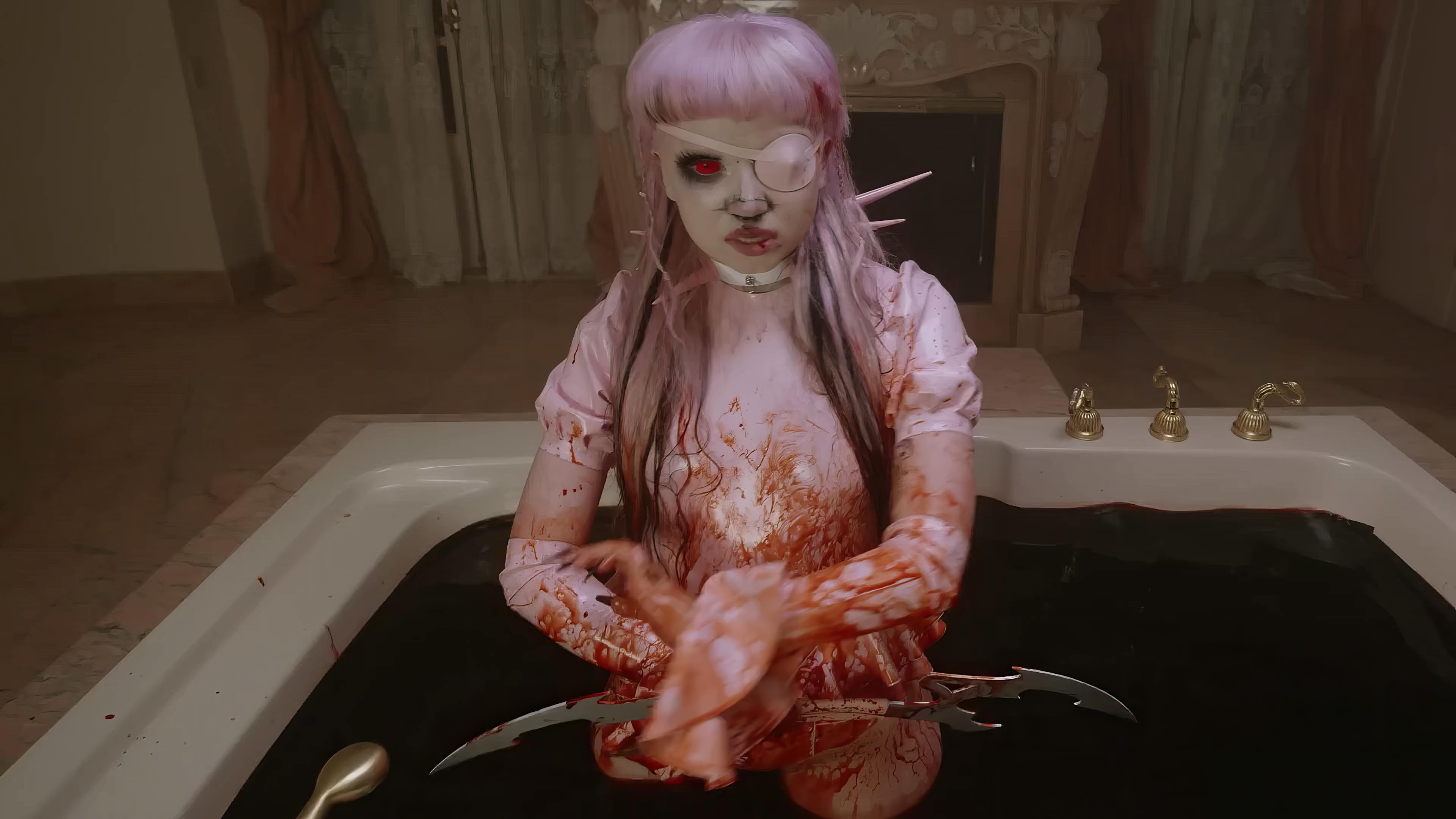 The artist, with an avant-garde appearance, is seated in a bathtub filled with blood. They have pastel pink hair and a stark white facial prosthetic covering one eye, creating a surreal and intense visual. The room's vintage decor adds to the gothic ambiance of the scene.