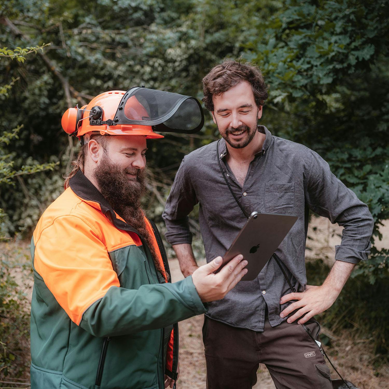 Ein Förster und ein Holzfäller bei der Anwendung der Dynamic Forest App bei der Arbeit im Wald
