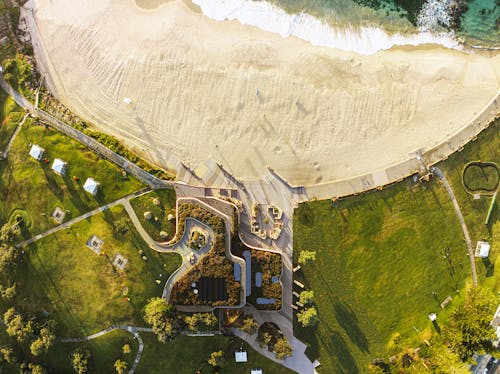 A digital render of a beach, viewed from above, with a contemporary surf life saving club embedded in the landscape.