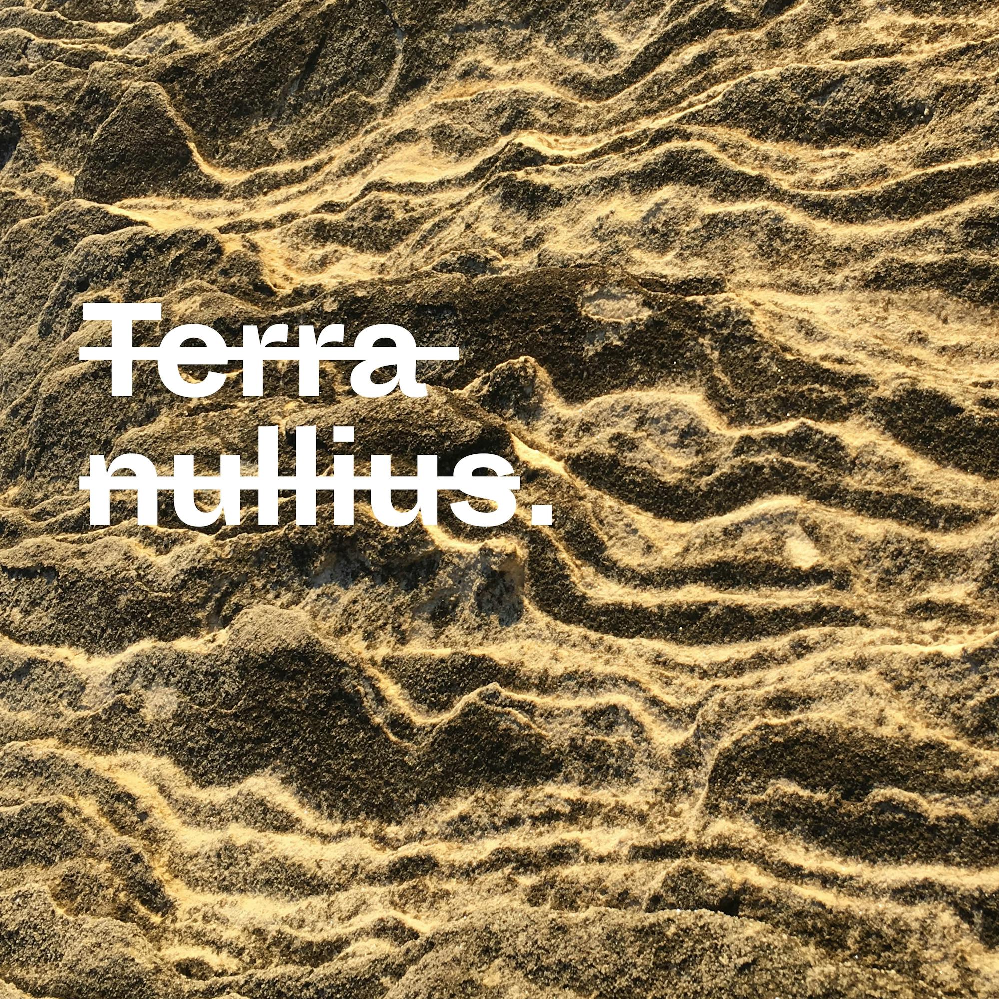 Photograph of undulating sandstone, with white text, crossed out, that reads 'terra nullius.'