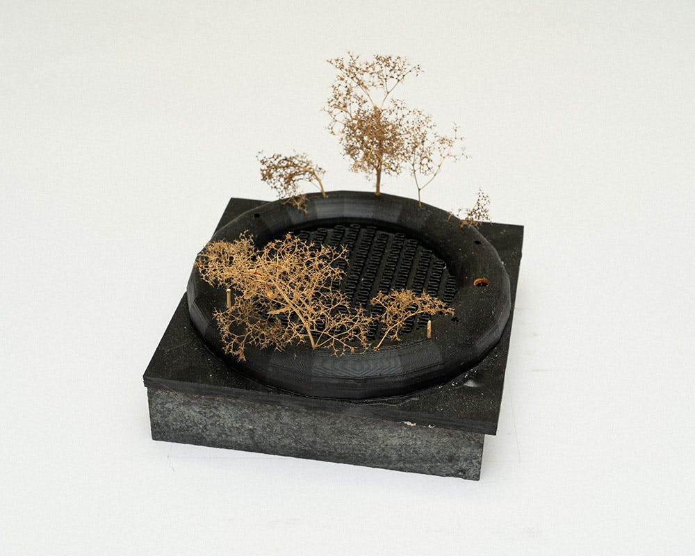 A photo of a small conceptual landscape model on a black base.