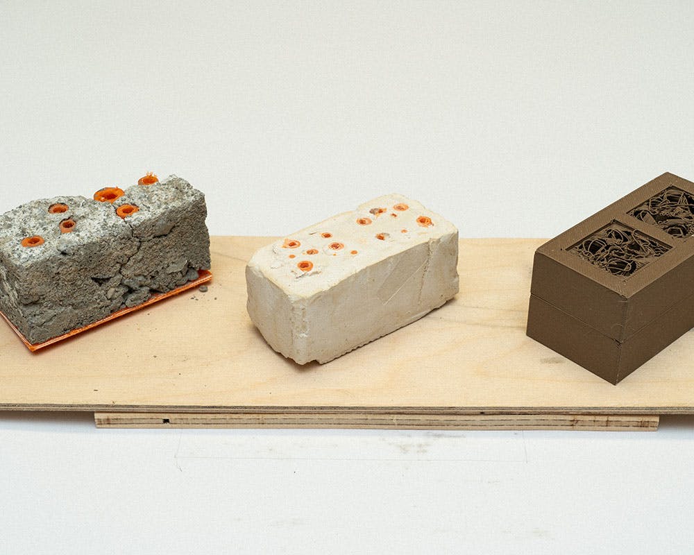 A photo of a small conceptual landscape model on a plywood base.