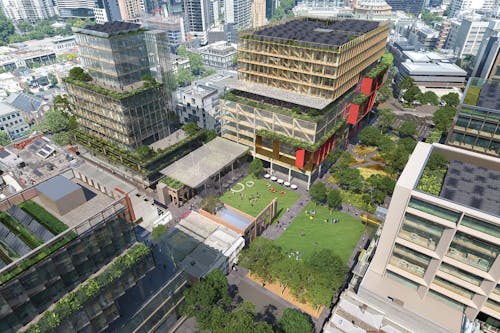 A digital render of a dense city precinct, with green open space at the centre, and green planting extending up on building terraces and rooftops.