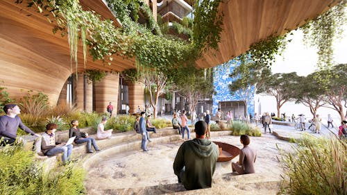 A digital render of people gathering in a semi-enclosed, round, courtyard-like, outdoor space. There are grassy plants in the foreground, hanging plants above, and trees seen in the distance. 