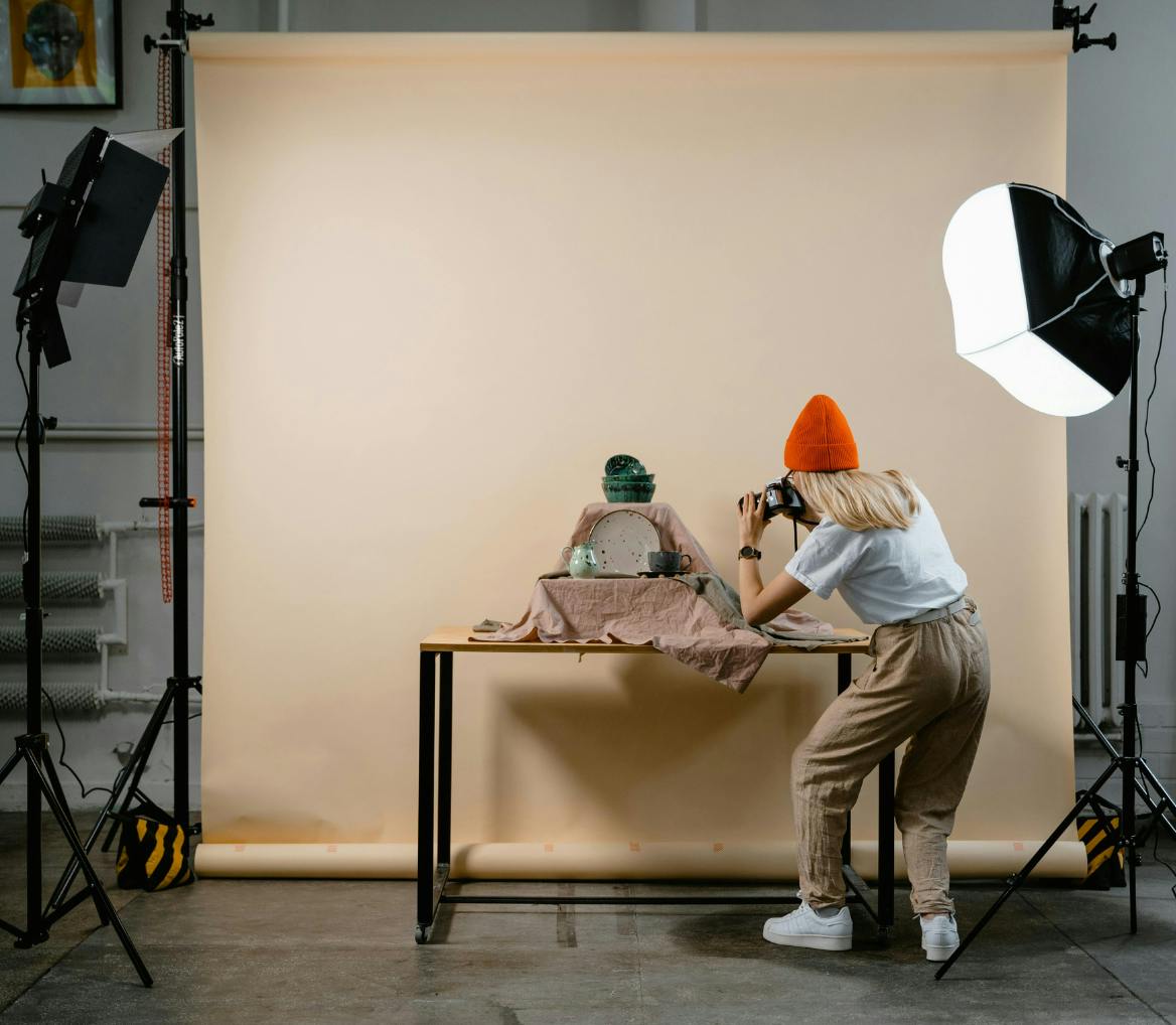 woman photographer in a photo studio taking photos of plates