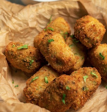 8 crispy golden brown broccoli croquettes garnished with parsley