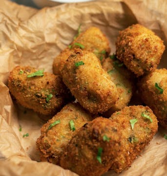 8 crispy golden brown broccoli croquettes garnished with parsley 