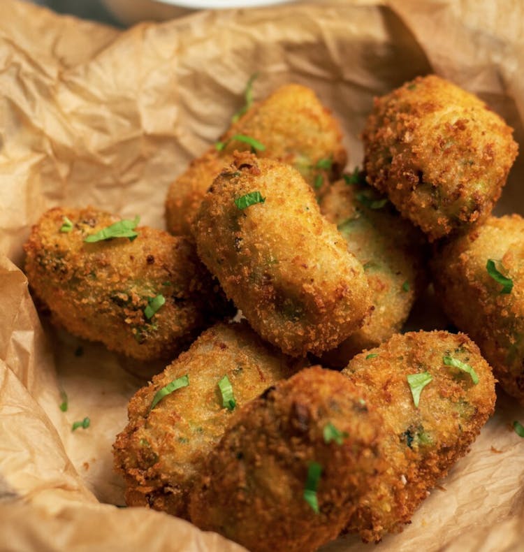 8 crispy golden brown broccoli croquettes garnished with parsley 