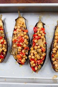 a mixture of onions, chickpeas, peppers and aubergine flesh inside the skin of an aubergine 