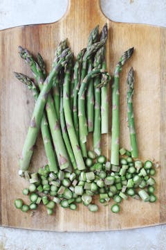 bunch of asparagus on a chopping board