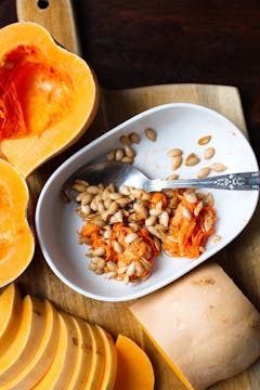 Butternut squash seeds in bowl with a spoon