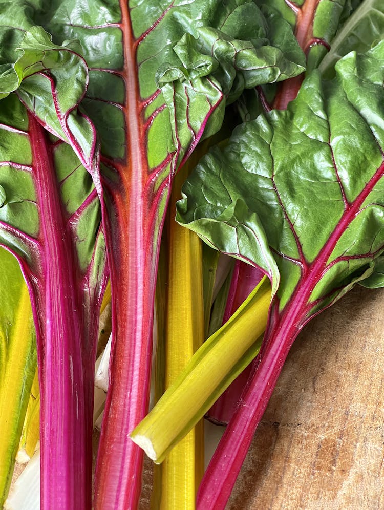 rainbow chard leaves on a wooden surface