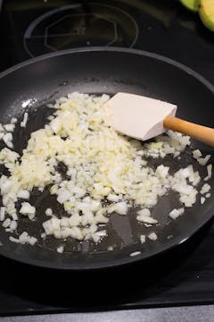 chopped onion being cooked in frying pan