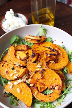 Roasted squash and rocket and seeds in large mixing bowl 