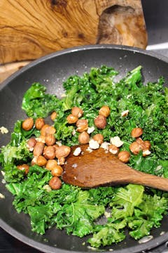 kale and hazelnuts in frying pan 